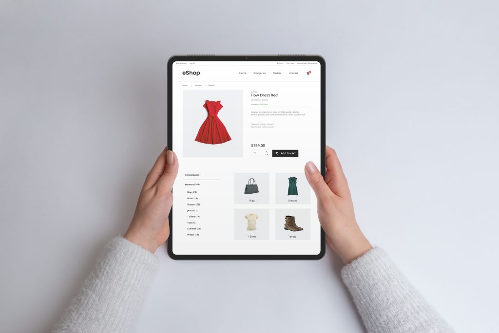 Tablet showing an online fashion product page with a red dress image and price on screen